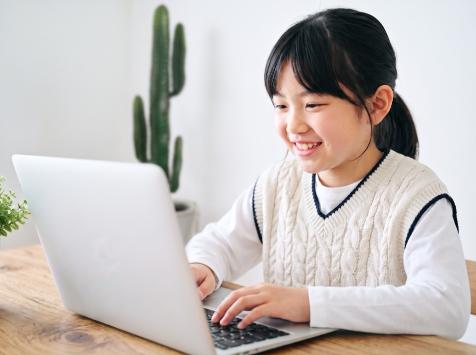 ノートパソコンで楽しそうに学習する女の子